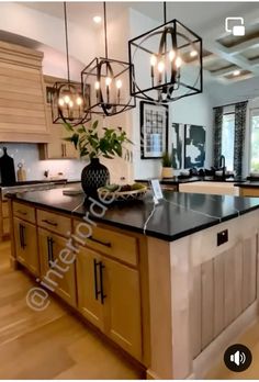 a large kitchen with an island and chandelier hanging from it's ceiling