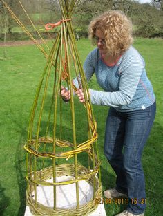 a woman is working on a sculpture in the grass