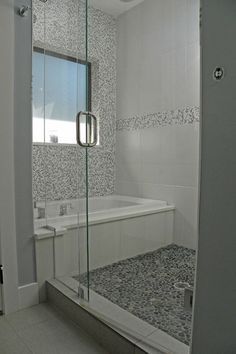 a bathroom with a walk in shower next to a white bath tub and tiled walls