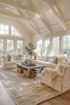 a living room filled with white furniture and lots of windows in the ceiling above it