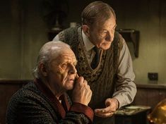 an older man and younger man sitting at a table