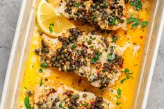 fish with capers and lemon on top in a baking dish, ready to be eaten