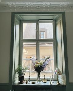 a vase with flowers sitting on a window sill