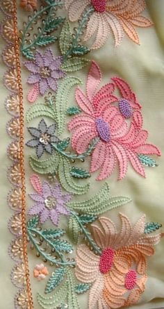 an embroidered piece with flowers and leaves on it's side, in pastel colors