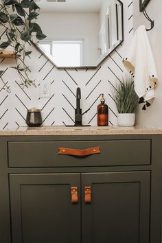 a bathroom vanity with a mirror, soap dispenser and plants on it