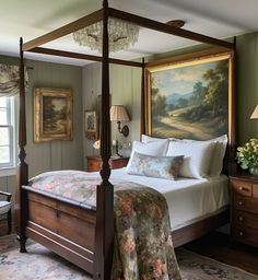 a bed sitting in a bedroom next to a painting on the wall and dressers