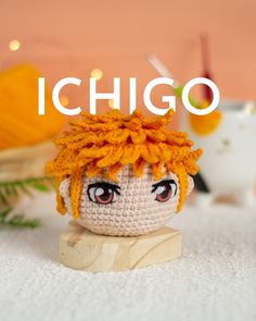 a small crocheted doll sitting on top of a white surface with the words ichigo in front of it