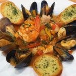 a white plate topped with mussels and shrimp