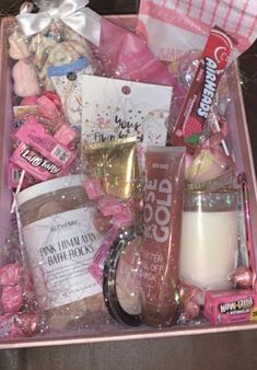 a pink box filled with lots of candy and other items on top of a table