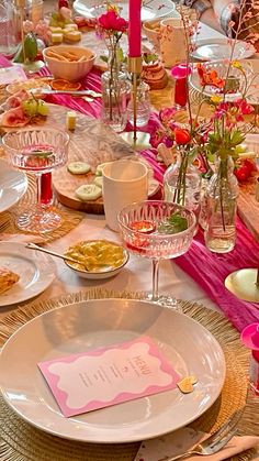 the table is set with pink and white dishes