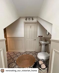 a white toilet sitting in a bathroom next to a sink