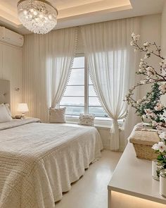 a bedroom with a large bed and chandelier hanging from it's ceiling