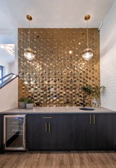 a kitchen with wooden flooring and an artistic metal wall behind the countertop area