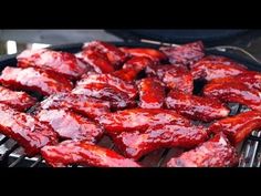 bbq ribs covered in ketchup sitting on top of a grill