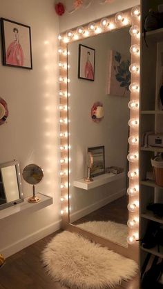 a mirror that has lights on it in a room with white walls and wooden floors