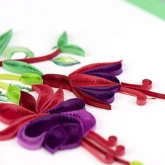 several pieces of paper with flowers cut out of them sitting on a white table top