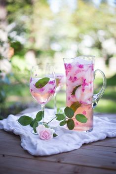 two glasses filled with water and pink flowers