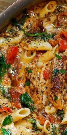 a pan filled with pasta and vegetables on top of a wooden table