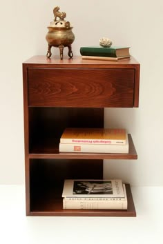 a book shelf with books and a vase on top