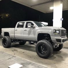 a white truck parked in front of a gas station