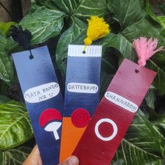 three paper bookmarks with different designs on them, one is red and the other is blue