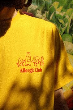 an allergyic club t - shirt is shown in front of a green plant