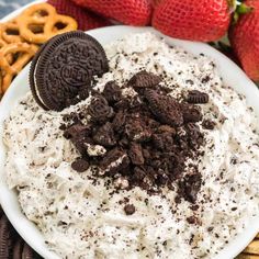 an oreo cookie and cream dip in a white bowl with pretzels on the side