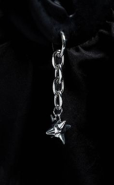 a silver chain with a star charm hanging from it's end on a black background