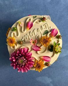 a cake decorated with flowers and the word congratulations on it's frosted icing