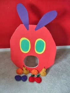 a red paper bag with an animal face on it's side and some candy in front of it