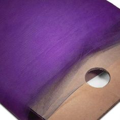 a roll of purple colored fabric with holes in the center and on top of it