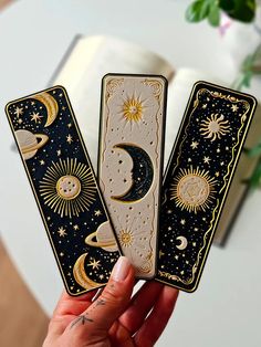 two tarot cards with the moon and stars on them in front of a book