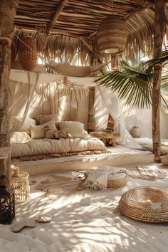 a bed with lots of pillows on top of it in the middle of some sand