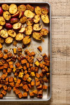 a pan filled with cooked sweet potatoes on top of a wooden table