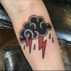 a black and red cloud with lightning bolt tattoo on the left arm, by person's foot