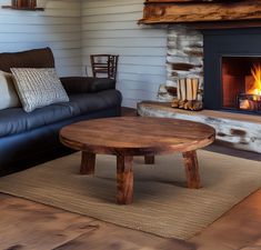 a living room with a fire place and couches in front of a wood burning fireplace