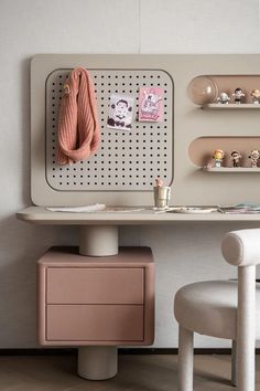 a white desk with two chairs and a pink coat rack on the wall above it