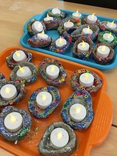 there are many cupcakes with lit candles in them on the tray next to each other