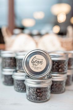 several jars filled with black beans sitting on top of a table