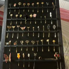 a display case filled with lots of different types of pins and brooches on black boards