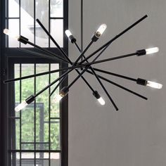 a large chandelier with eight lights hanging from it's sides in front of a window