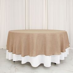 a round table with a tan cloth on it