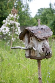 a bird house made out of wood in the grass