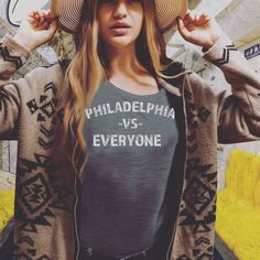 a woman wearing a hat and sweater with the words philadelphia vs everyone printed on it