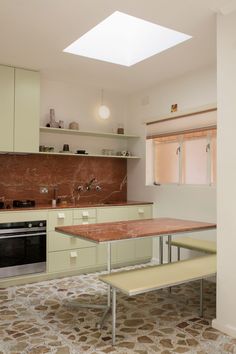 a kitchen with an oven, sink and table in the middle of it's room