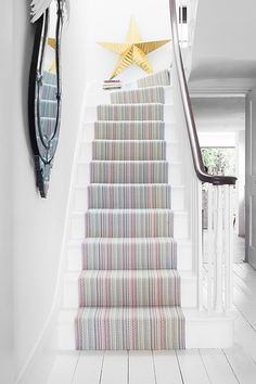 the stairs are decorated with multicolored rugs and star decorations above them, along with a clock on the wall