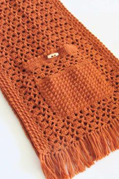 an orange crocheted scarf with fringes