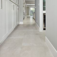 a long hallway with white cabinets and counter tops