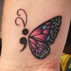 a small butterfly tattoo on the wrist is shown in black and pink colors, with swirls coming out of it's wings