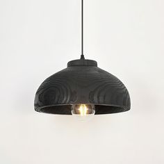 a black pendant light hanging from a ceiling